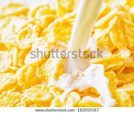 Milk pouring  into corn flakes.