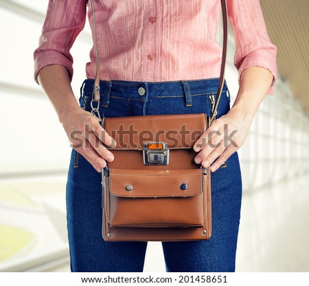 Young woman in deep blue jeans holding a bag. Retro style.