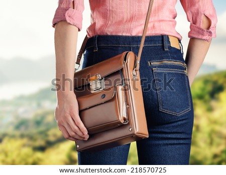 Young woman in deep blue jeans holding a bag. Retro style.