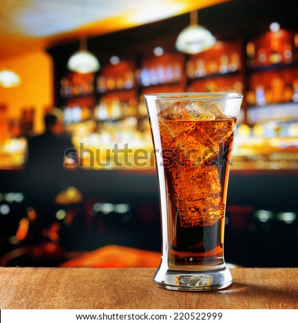Glass of cola with ice in a bar.