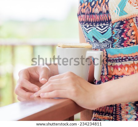 Young woman enjoying a mug of beverage. Outdoor portrait. Coffee and tea drinking conception.