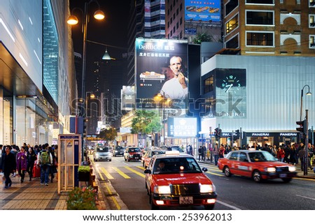 HONG KONG - JANUARY 31, 2015: Taxi and illuminated signs on streets of night city Hong Kong. Hong Kong is a popular tourist attraction of Asia and leading financial centre of the world.
