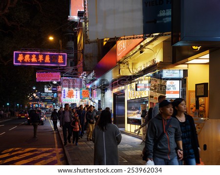 HONG KONG - JANUARY 30, 2015: Pedestrians and illuminated signs on the street of night city. Hong Kong is popular tourist destination of Asia and leading financial centre of the world.