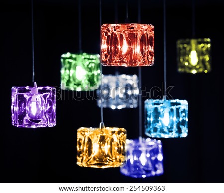 Closeup view of contemporary light fixture on a dark background. Small colorful bright lights creating a festive and romantic atmosphere.