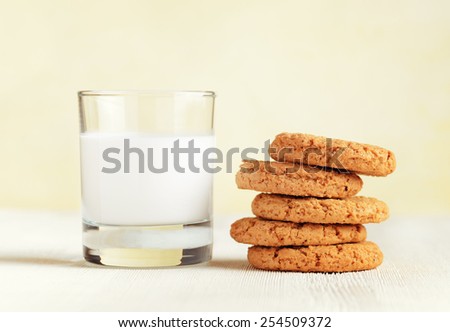Oatmeal cookies and glass of milk on a wooden table. Organic healthy food rich in calcium, minerals and vitamins. Eco food for breakfast. Sweet confectionery for hipsters.