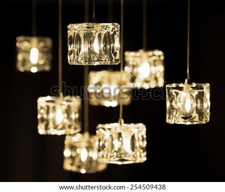 Closeup view of contemporary light fixture on a dark background. Small bright lights creating a festive and romantic atmosphere.