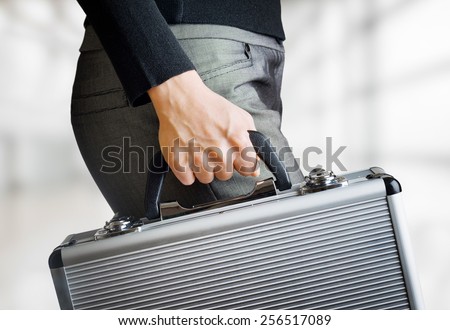 Business woman holding an aluminum briefcase and hurrying to work. Confident woman preparing for important negotiations and deals. Money and documents in safe hands of office worker.