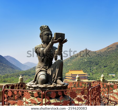 One of Buddhist statues praising and making offerings to the Tian Tan Buddha. The Po Lin Monastery in the background at Lantau Island, in Hong Kong. Hong Kong is popular tourist destination of Asia.