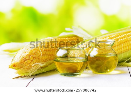 Corn oil and corn cobs on a garden table.