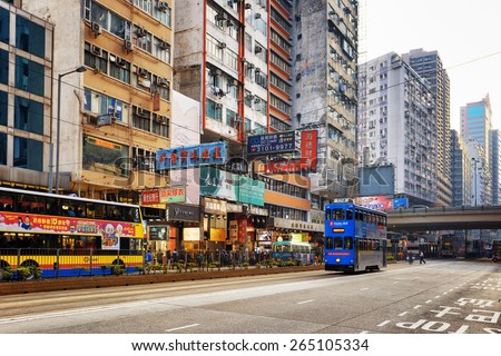 HONG KONG - JANUARY 31, 2015: Decker buses and trams on the central street. Hong Kong is popular tourist destination of Asia and leading financial centre of the world.