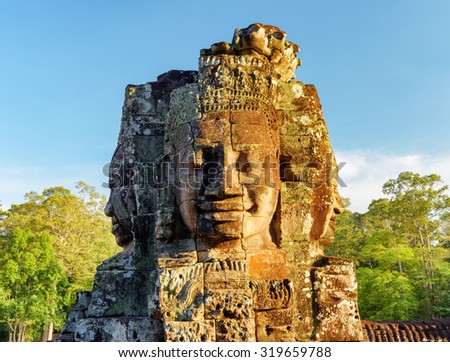 Enigmatic face-tower of ancient Bayon temple in evening sun. Mysterious Bayon temple nestled among rainforest in Angkor Thom, Siem Reap, Cambodia. Amazing Angkor Thom is a popular tourist attraction.