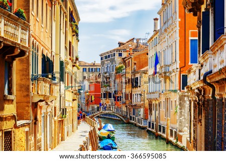 View of the Rio Marin Canal and the Ponte Cappello dei Garzoti from the Ponte de la Bergami in Venice, Italy. Colorful facades of old houses. Venice is a popular tourist destination of Europe.