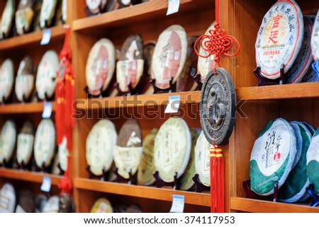 LIJIANG, YUNNAN PROVINCE, CHINA - OCTOBER 23, 2015: Traditional Chinese tea on wooden shelves at tea shop in the Old Town of Lijiang. Disks of Yunnan Puer. Shallow depth of field.