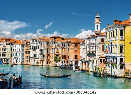 View of the Grand Canal with gondolas and colorful facades of old medieval houses from the Rialto Bridge in Venice, Italy. Venice is a popular tourist destination of Europe.