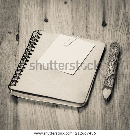 brown notebook and a pencil on wood background,Old style color