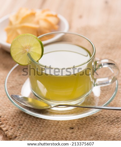 lemon green tea with cookie on wood background