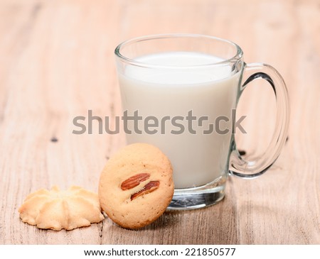 cup of milk wite cookies on wood table