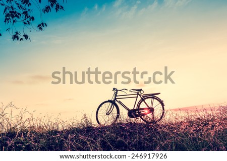 beautiful landscape image with Silhouette  Bicycle at sunset in vintage tone style