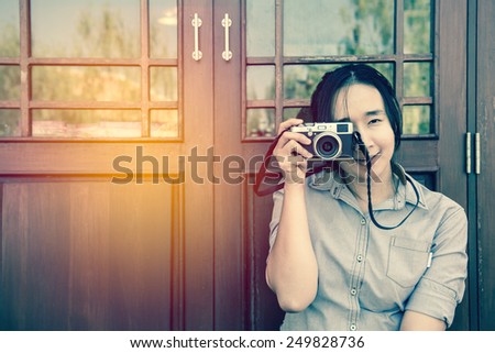 beautiful woman with classic camera in hand ; vintage filter effect