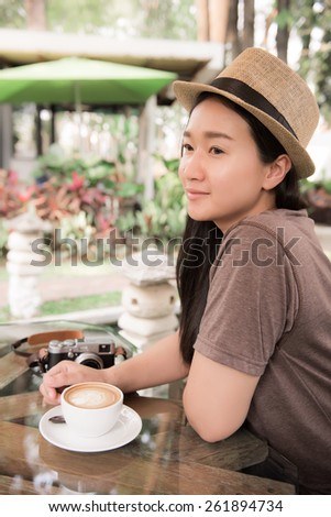 beautiful woman with coffee latte art in garden