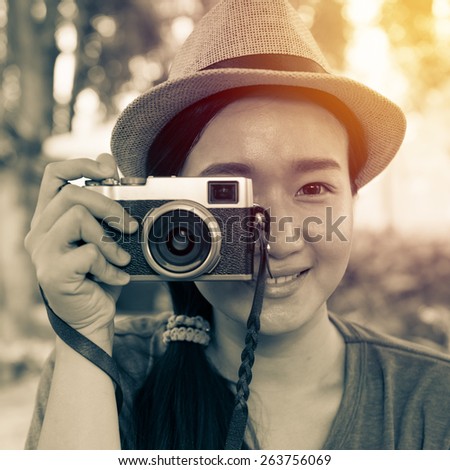 beautiful asian woman with classic camera in hand ; vintage filter effect