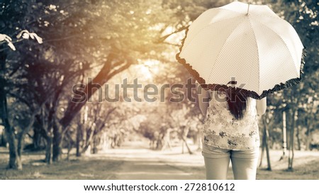 Portrait of Asian back woman holding umbrella ; vintage filter tone style