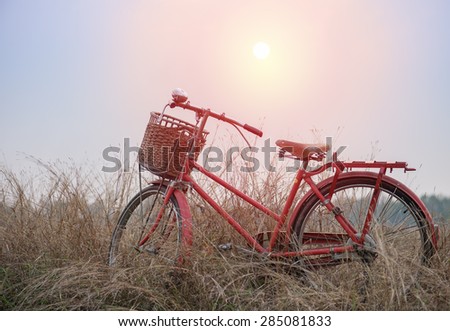 beautiful landscape image with vintage bicycle at sunset ; vintage filter style