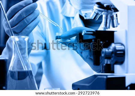 Conical flask in scientist hand with lab glassware background, Laboratory research concept