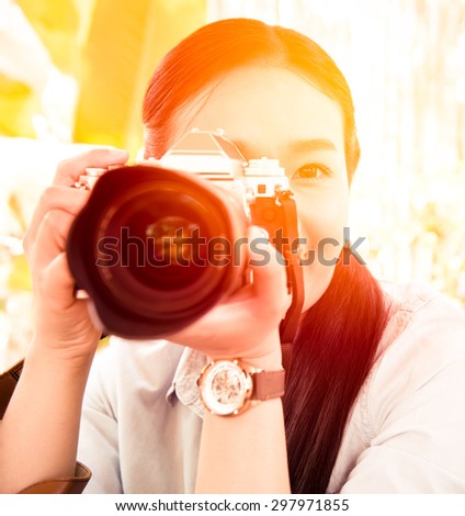 beautiful woman with classic camera in hand ; vintage filter effect