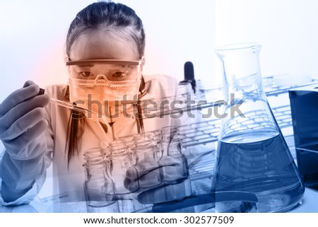 female medical or scientific researcher or woman doctor looking at a test tube of clear solution in a laboratory