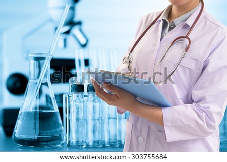 scientist or doctor writing report with equipment and science experiments