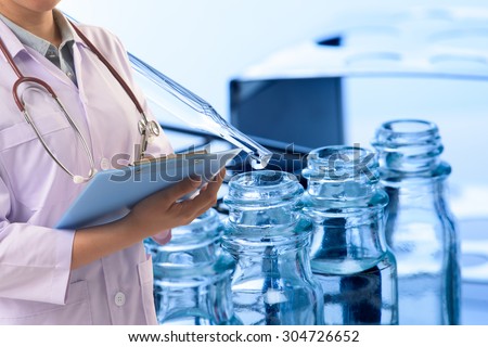scientist writing report with equipment and science experiments