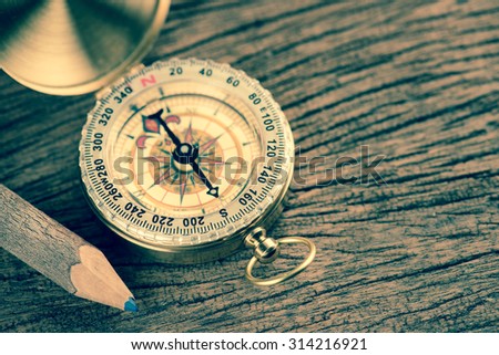 Old  gold vintage compass with pencil on wood background;vintage tone style