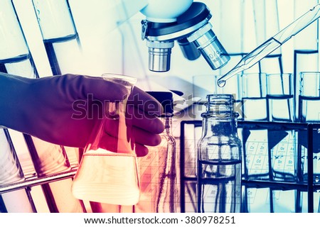 Laboratory research, flask containing chemical liquid with microscope