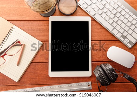 mockup tablet similar to ipad style on wood desk. black display.keyboard and office stuff, workplace, top view