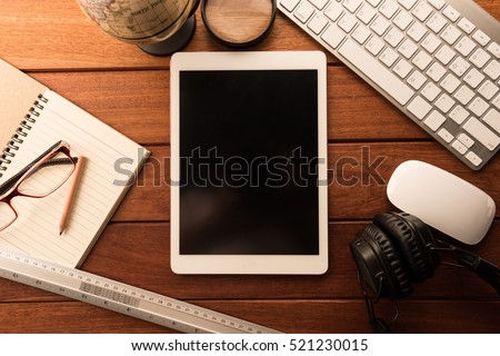 mockup tablet similar to ipad style on wood desk. black display.keyboard and office stuff, workplace, top view
