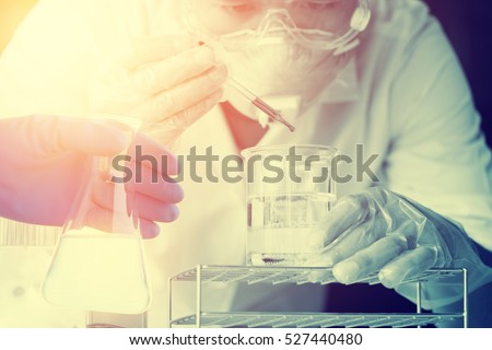 Flask in scientist hand with test tubes