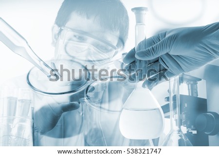 Flask in scientist hand with dropping chemical liquid to test tubes, science and medical research and development concept