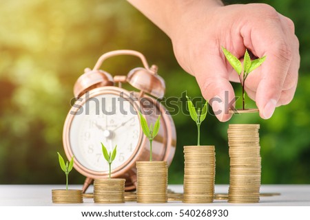 Close up of male hand stacking gold coins with green bokeh background ,Business Finance and Money concept,Save money for prepare in the future.