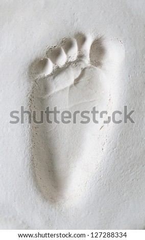 closeup of imprint of the child foot in white clay (gypsum)