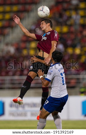 PATHUMTHANI THAILAND-MAY05:Sergio Suarez(Crimson)of Police Utd.jumps for the ball during a Thai Premier League match between Police Utd. & Songkhla Utd.at Thammasat Stadium on May 05,2014,Thailand