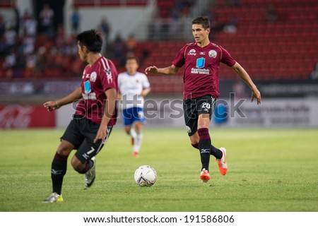 PATHUMTHANI THAILAND-MAY 05:Sergio Suarez(Crimson)of Police Utd. runs for the ball during the Thai Premier League match between Police Utd.and Songkhla Utd.at Thammasat Stadium on May 05,2014,Thailand