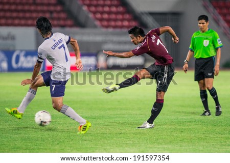 PATHUMTHANI THAILAND-MAY 05:Tana Chanabut(Crimson)of Police Utd.hit the ball during  Thai Premier League match between Police Utd.and Songkhla Utd.at Thammasat Stadium on May 05,2014,Thailand
