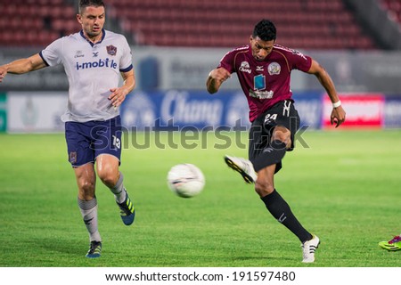 PATHUMTHANI THAILAND-MAY 05:Michael Murcy(Crimson)of Police Utd. hit the ball during the Thai Premier League match between Police Utd.and Songkhla Utd.at Thammasat Stadium on May 05,2014,Thailand