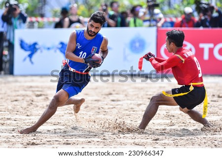 PHUKET,THAILAND-NOV14:Abdullah Dawoud of Kuwait is tagged during the gold medal  Beach Flag Football Kuwait and Thailand during the 2014 Asian Beach Games at Saphan Hin on NOVEMBER14,2014 in Thailand.