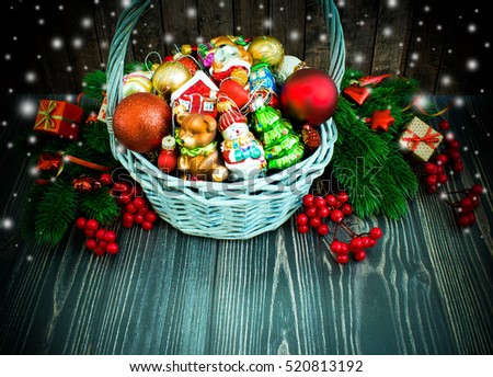 Christmas or New Year background: basket, colored glass balls and toys, decoration on wooden background with snow