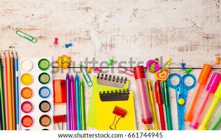 School stationery products such as paper clips, pins, notebooks, pens, pencils, rulers, scissors lying on white wooden table with space to write your text