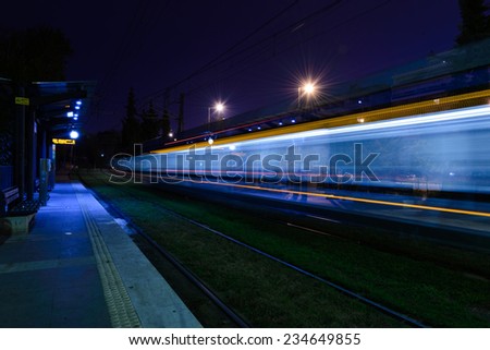 Moving Train passing by an empty train station at night