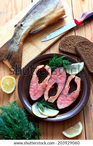Pink salmon slices on the brown ceramic plate