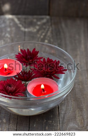 Red candles and flowers floating in the glass bowl